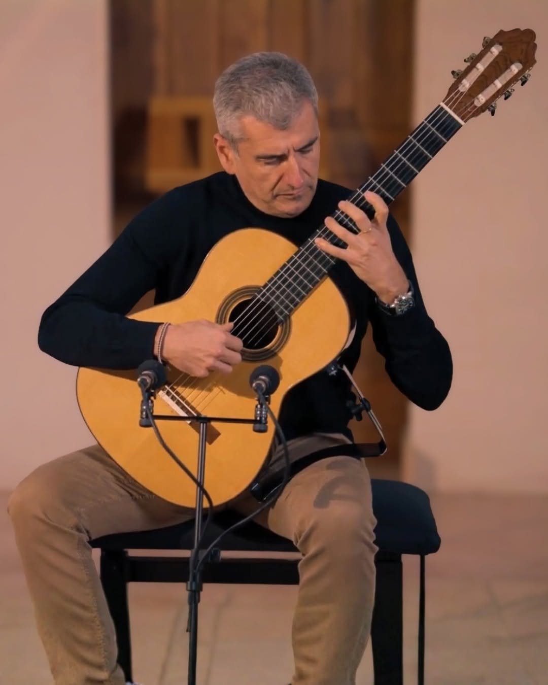 Alexandre Bernoud performing on stage in black, playing classical guitar