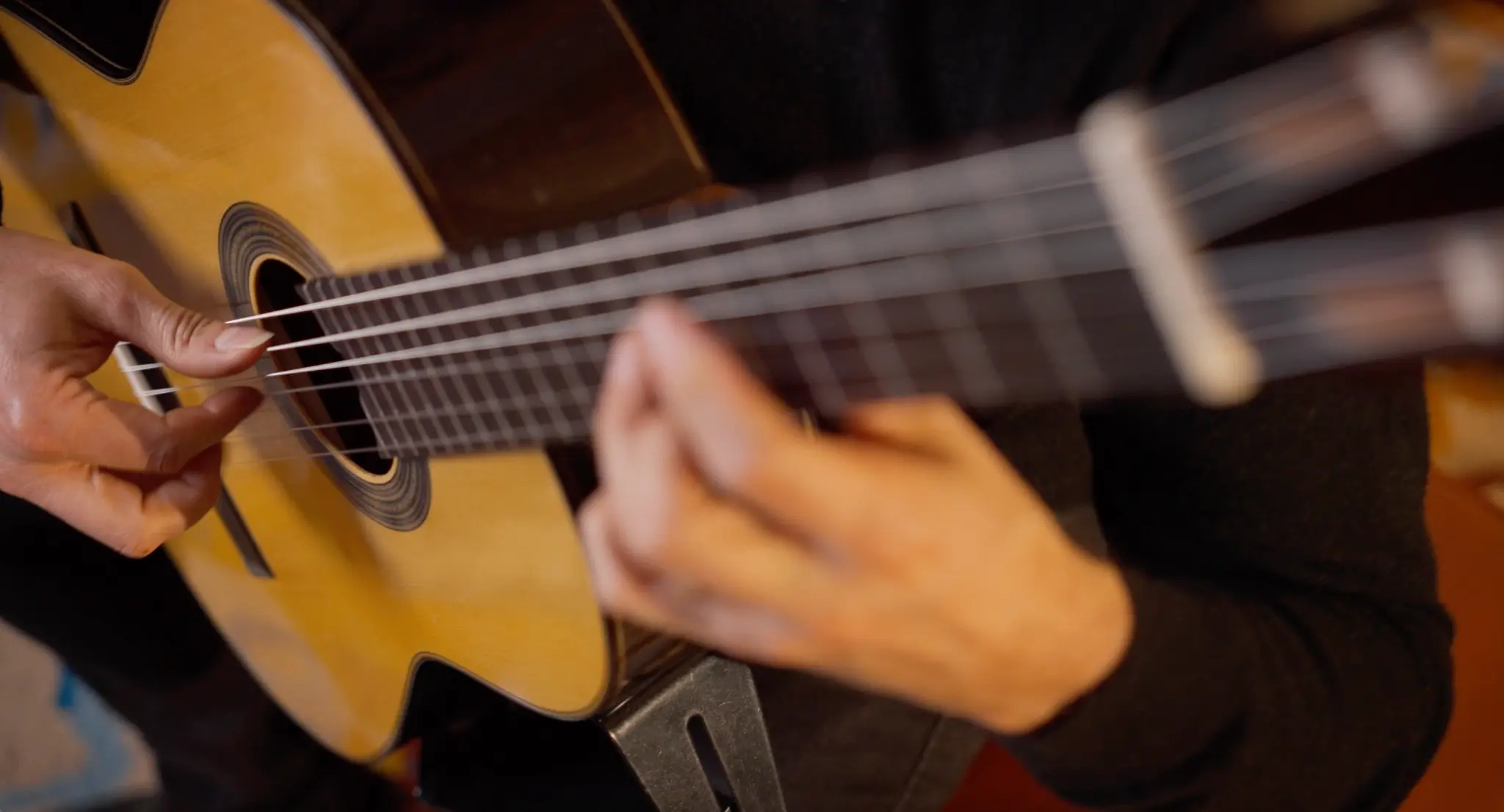 A close-up of Alexandre Bernoud’s hands as he plays the guitar